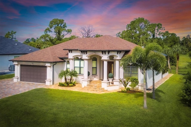 mediterranean / spanish house featuring a garage and a yard