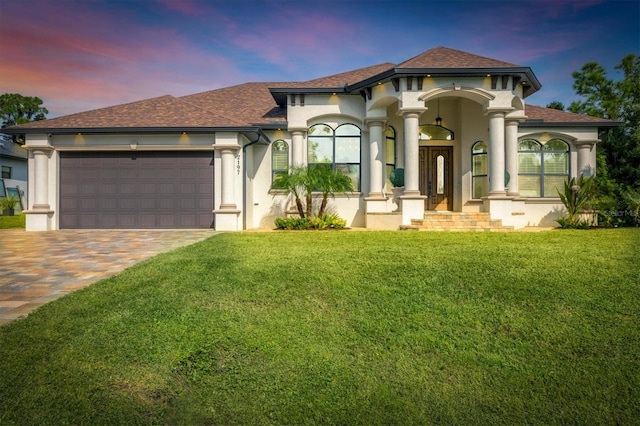 mediterranean / spanish-style house featuring a garage and a lawn