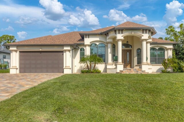 mediterranean / spanish home featuring a garage and a front yard