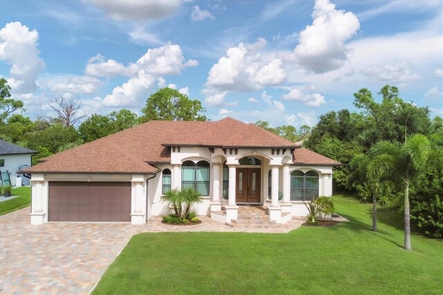 mediterranean / spanish-style home featuring a front yard and a garage