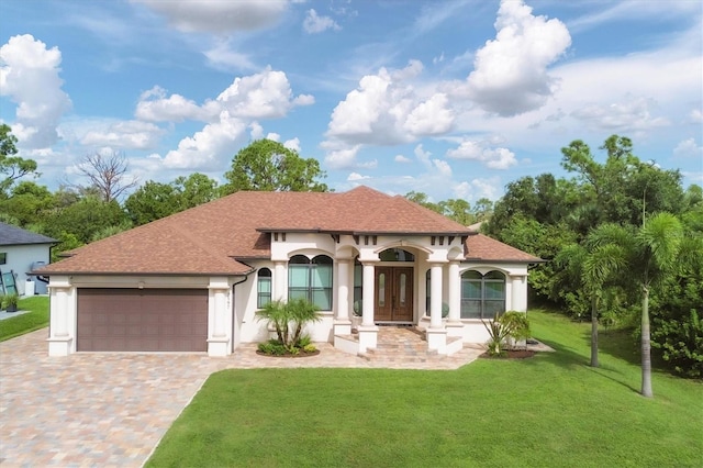 2197 Nita Ter, North Port, FL 34286 - mediterranean / spanish-style house featuring a shingled roof, a front yard, stucco siding, decorative driveway, and an attached garage