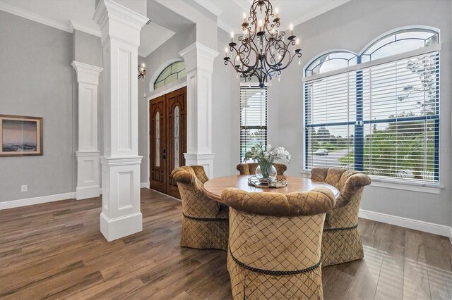 dining room with decorative columns, ornamental molding, dark hardwood / wood-style floors, and a chandelier