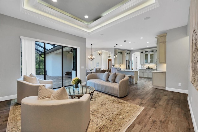 2197 Nita Ter, North Port, FL 34286 - living room with dark wood-style floors, baseboards, arched walkways, ornamental molding, and a raised ceiling