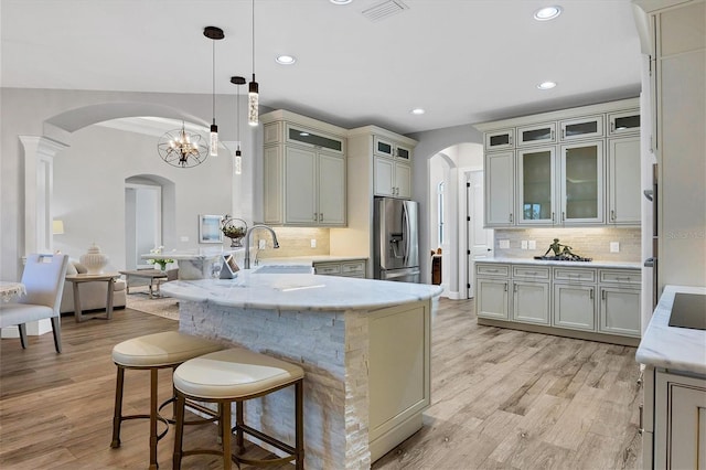 2197 Nita Ter, North Port, FL 34286 - kitchen featuring arched walkways, a sink, a peninsula, and stainless steel fridge with ice dispenser