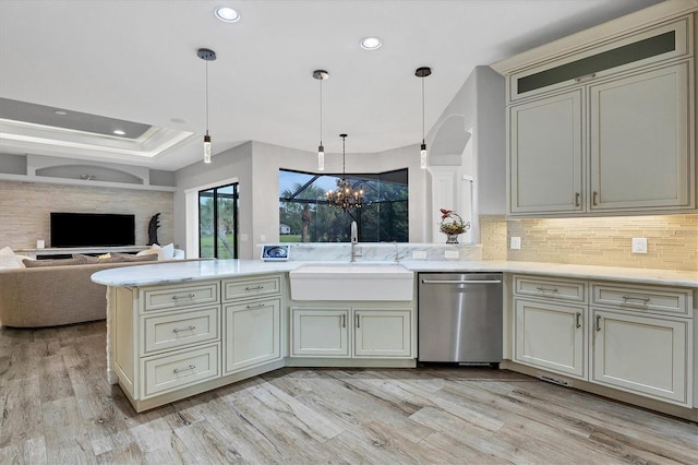 kitchen featuring cream cabinetry, an inviting chandelier, decorative light fixtures, stainless steel dishwasher, and sink