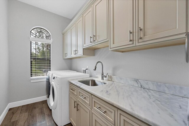 washroom with cabinets, wood-type flooring, independent washer and dryer, and sink