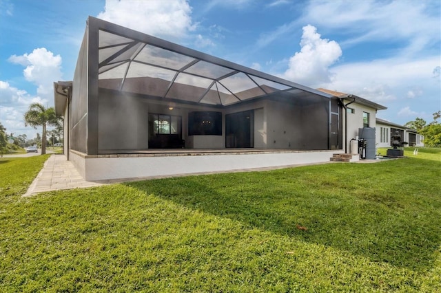 2197 Nita Ter, North Port, FL 34286 - rear view of property featuring stucco siding, a lawn, and a lanai