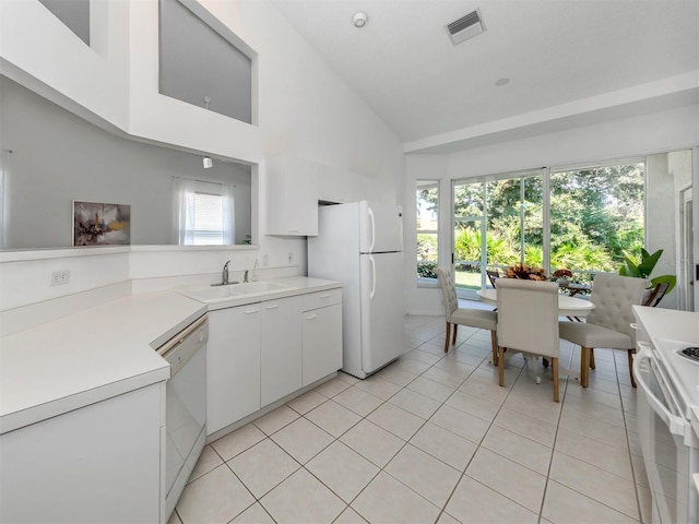 kitchen with white appliances, high vaulted ceiling, white cabinets, sink, and light tile patterned floors