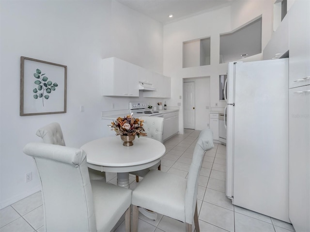 tiled dining area with a high ceiling