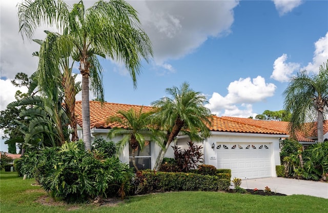 mediterranean / spanish home featuring a front yard and a garage