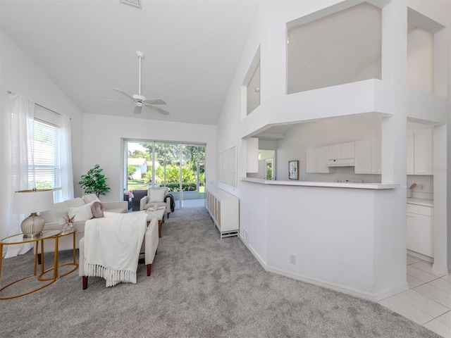 living room featuring ceiling fan, light colored carpet, radiator heating unit, and high vaulted ceiling