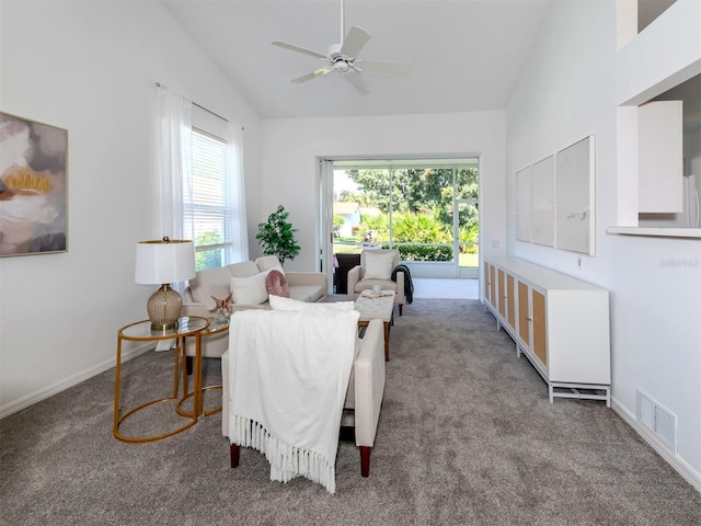 carpeted living room with a wealth of natural light, ceiling fan, and vaulted ceiling