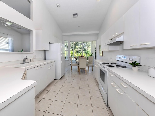 kitchen featuring white appliances, ceiling fan, light tile patterned floors, white cabinetry, and lofted ceiling