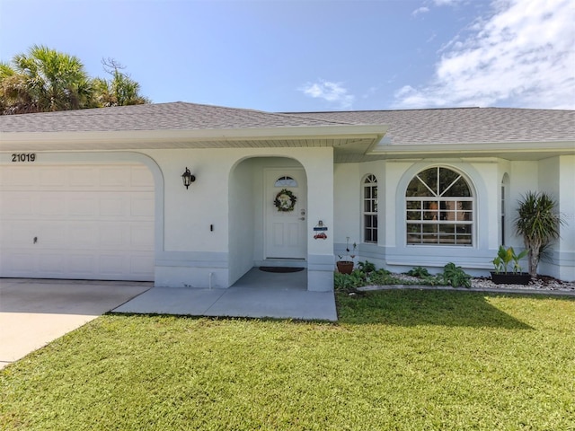 property entrance featuring a garage and a yard