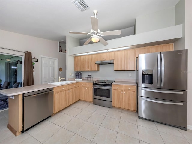 kitchen featuring light tile patterned floors, sink, kitchen peninsula, appliances with stainless steel finishes, and light brown cabinetry