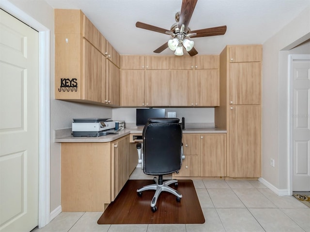 tiled office space with built in desk and ceiling fan