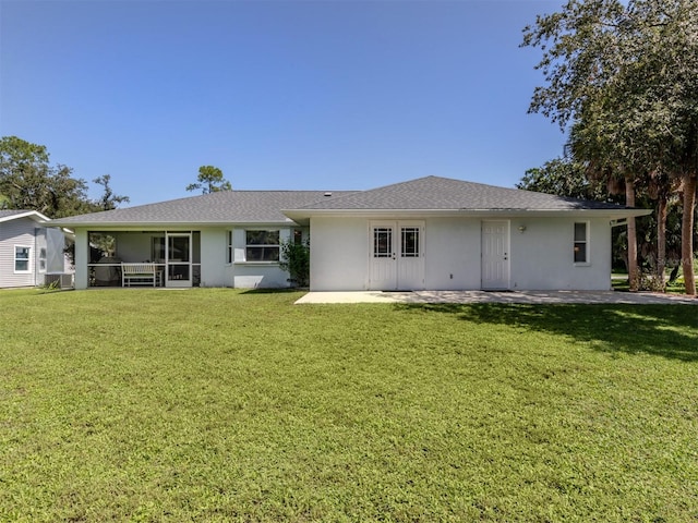 rear view of property with a sunroom and a yard