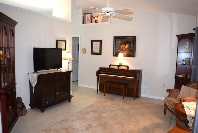 sitting room with high vaulted ceiling, ceiling fan, and light tile patterned floors