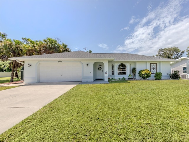 ranch-style home featuring an attached garage, driveway, a front yard, and stucco siding