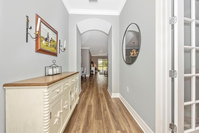 hallway featuring crown molding and light wood-type flooring