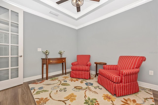 sitting room with hardwood / wood-style flooring, ceiling fan, and crown molding