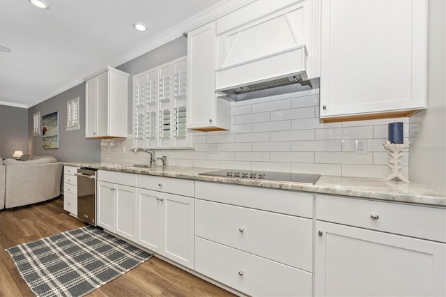 kitchen featuring white cabinetry, black electric stovetop, wood-type flooring, and ornamental molding