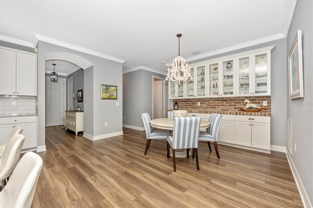 dining room with ornamental molding and light hardwood / wood-style flooring