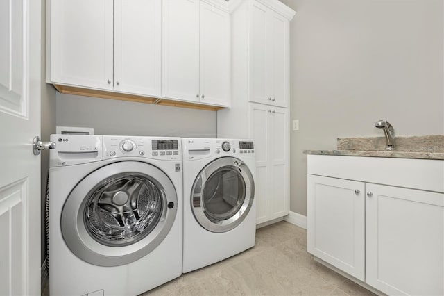 washroom with cabinets, separate washer and dryer, and sink