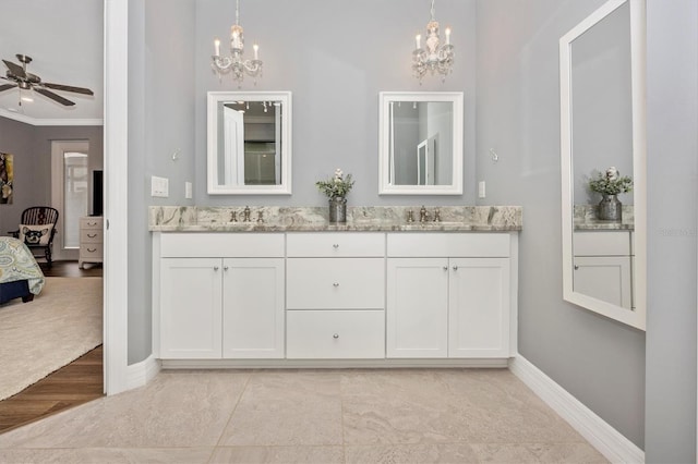 bathroom with ceiling fan with notable chandelier, ornamental molding, and vanity