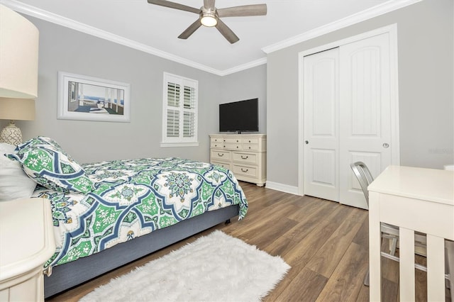 bedroom featuring ceiling fan, a closet, crown molding, and hardwood / wood-style flooring