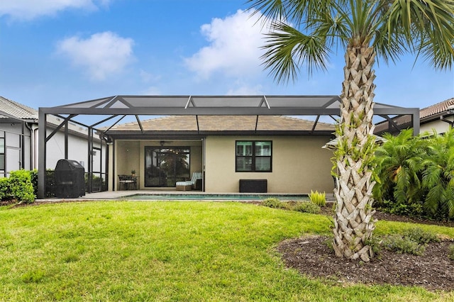 rear view of property featuring a lanai and a lawn