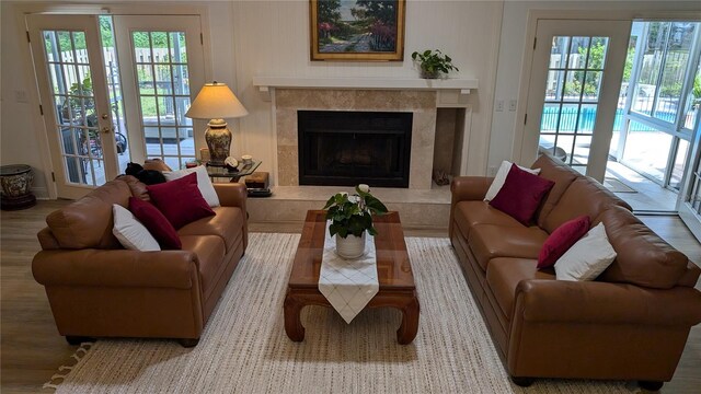 living room featuring a wealth of natural light, hardwood / wood-style floors, french doors, and a fireplace