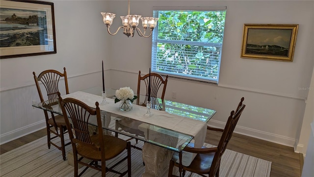 dining area with dark hardwood / wood-style flooring and an inviting chandelier