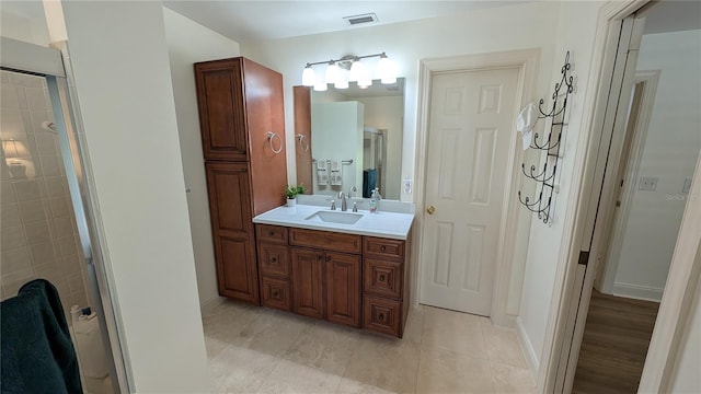 bathroom featuring tile patterned flooring, walk in shower, and vanity