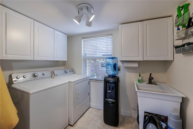 laundry area featuring cabinets, washer and clothes dryer, and sink