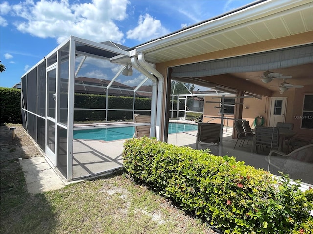 view of swimming pool featuring a patio area, ceiling fan, and a lanai