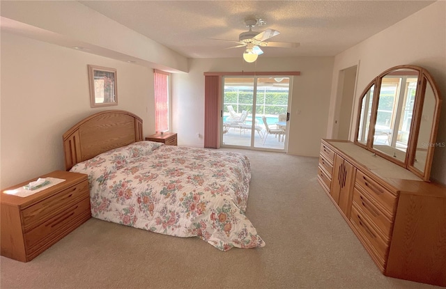 carpeted bedroom with access to outside, ceiling fan, and a textured ceiling