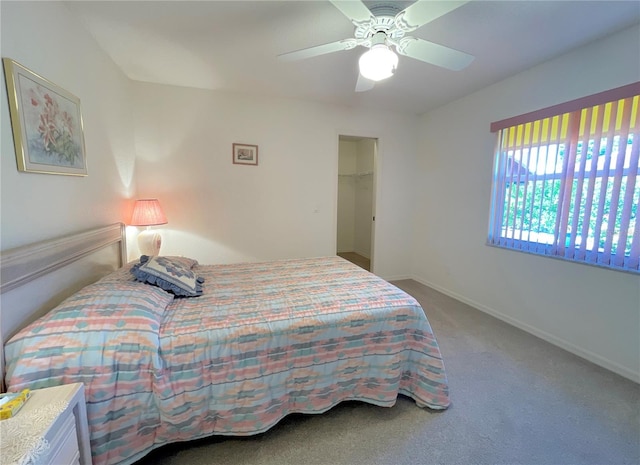 carpeted bedroom with a closet, a spacious closet, and ceiling fan