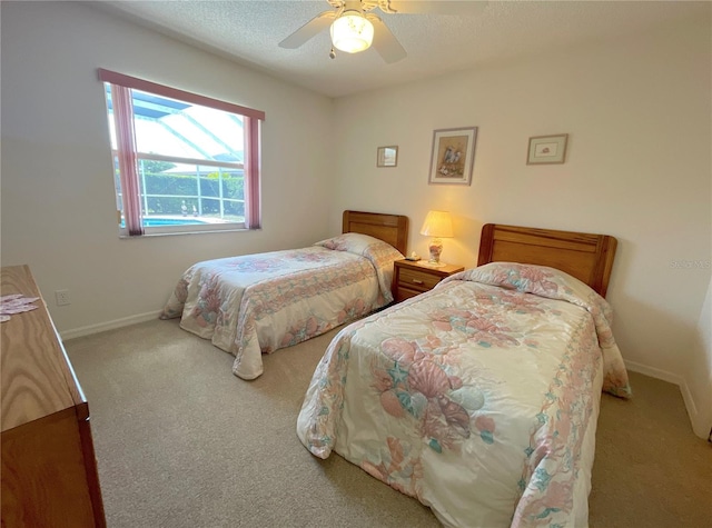 bedroom with ceiling fan, light colored carpet, and a textured ceiling