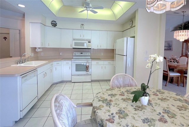 kitchen featuring sink, white cabinets, and white appliances