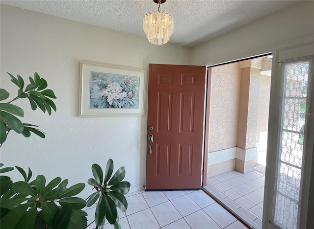 entrance foyer featuring a notable chandelier, light tile patterned floors, and a textured ceiling