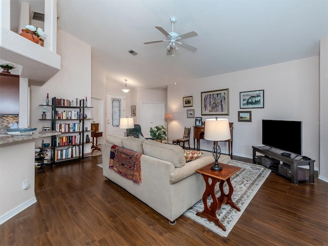 living room featuring dark wood-type flooring, ceiling fan, and vaulted ceiling