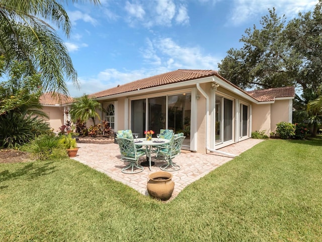 back of house featuring a lawn and a patio area