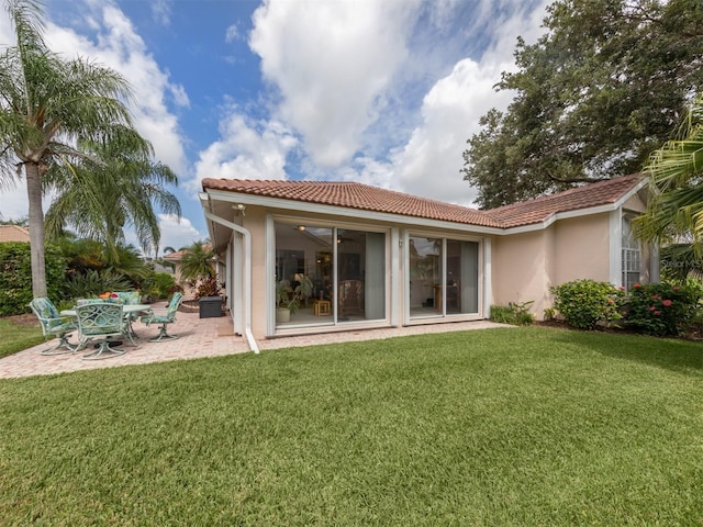 rear view of property with a yard and a patio