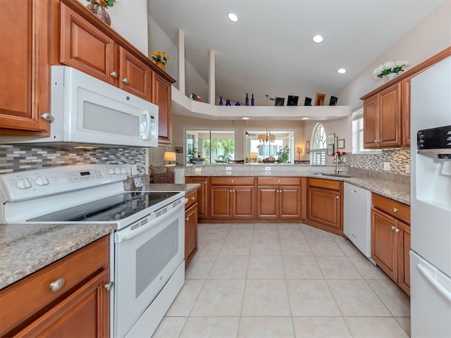 kitchen with white appliances, backsplash, light tile patterned floors, sink, and vaulted ceiling