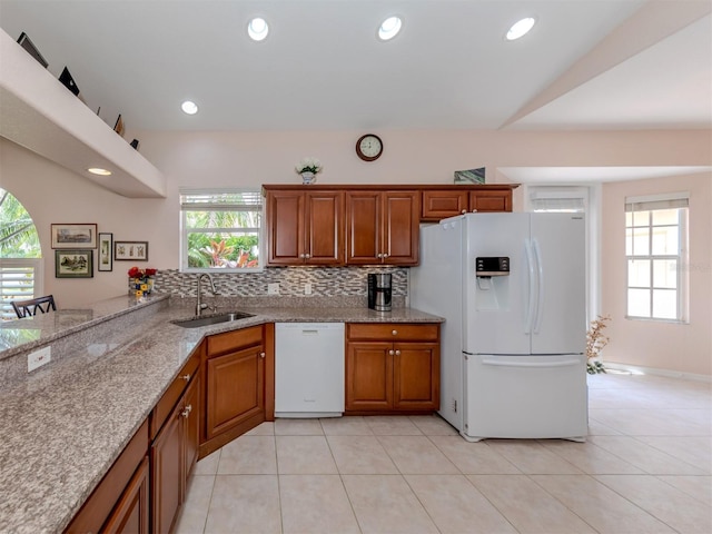 kitchen with white appliances, plenty of natural light, sink, and tasteful backsplash