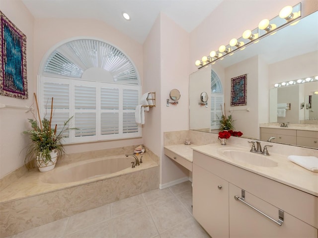 bathroom featuring lofted ceiling, vanity, tile patterned flooring, and a relaxing tiled tub