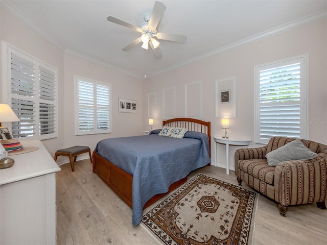 bedroom featuring ceiling fan, ornamental molding, light wood-type flooring, and multiple windows