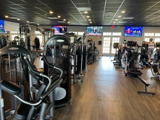 exercise room with a drop ceiling and wood-type flooring