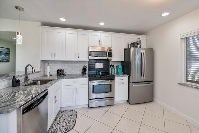 kitchen with white cabinetry, sink, light stone counters, and appliances with stainless steel finishes